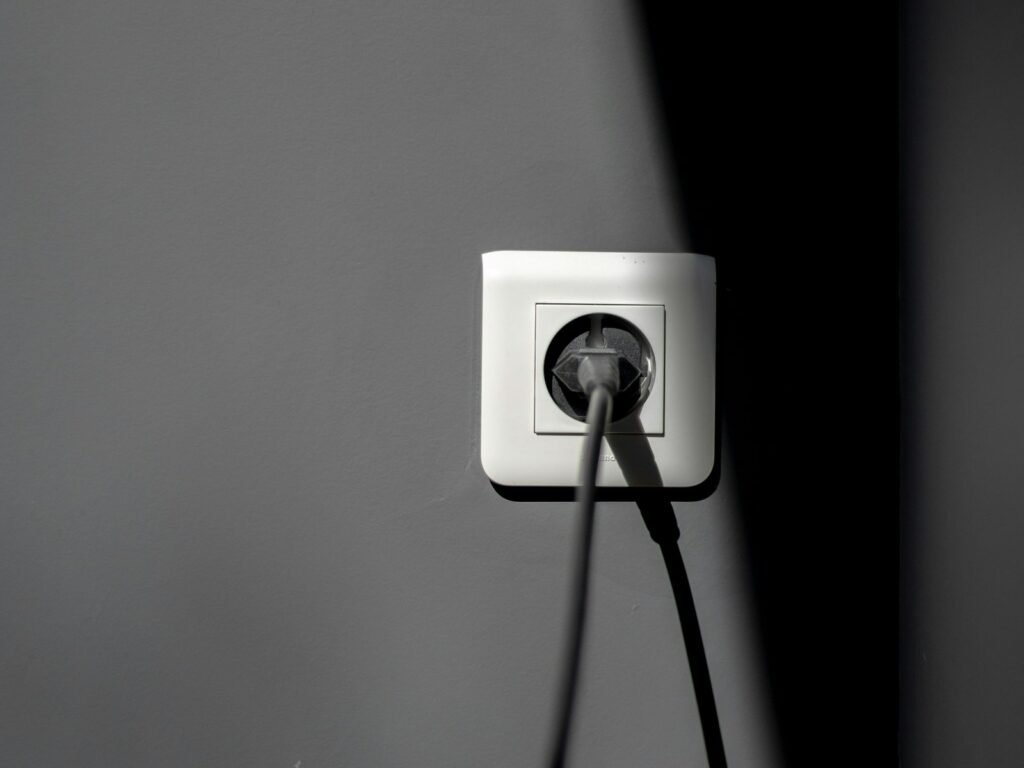 Prise connectée avec suivi de consommation : fiche électrique branchée sur une prise murale blanche (photo d’illustration)