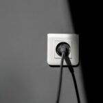 Prise connectée avec suivi de consommation : fiche électrique branchée sur une prise murale blanche (photo d’illustration)